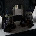 Decorative setup with vases, flowers, and a mirror in a room with dark curtains.