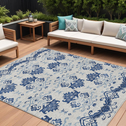 Blue and white patterned rug on a wooden floor with outdoor furniture in the background.